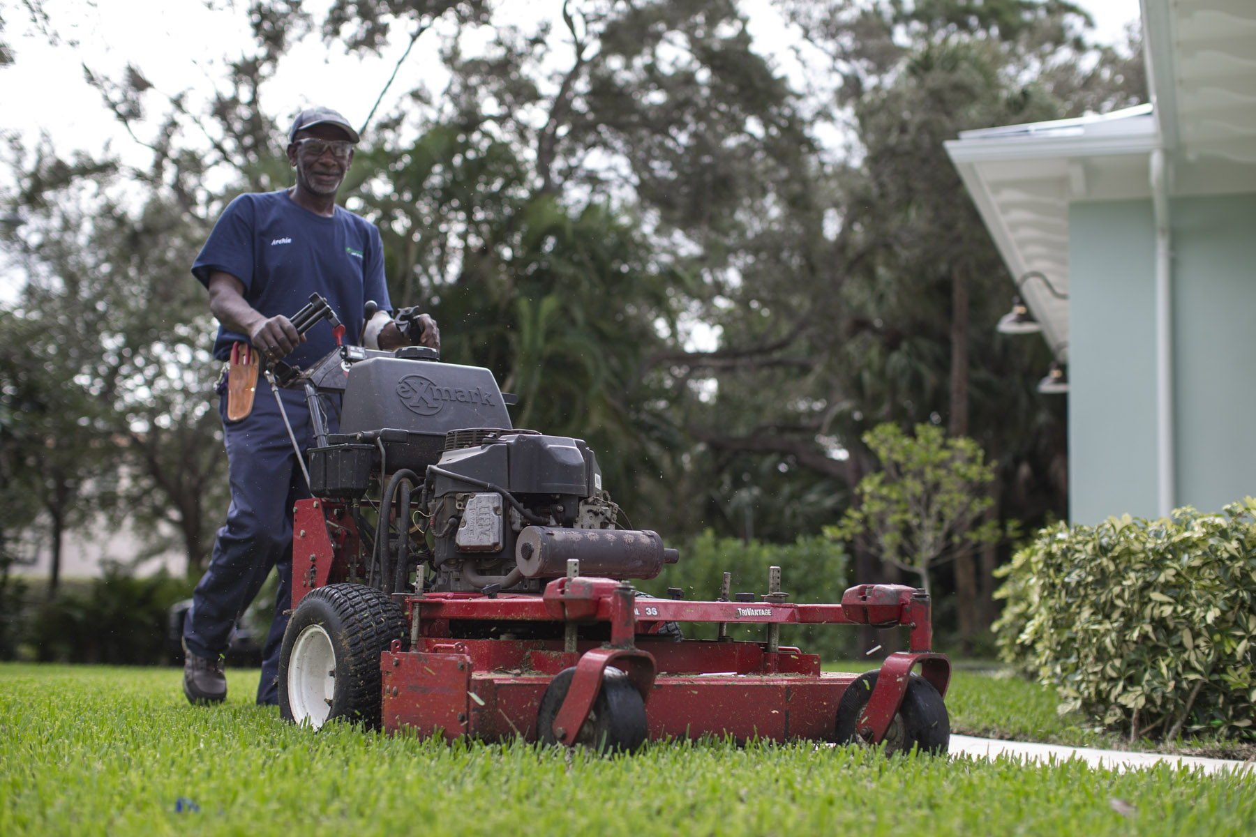 Florida Boys crew member mowing a pristine South Florida lawn