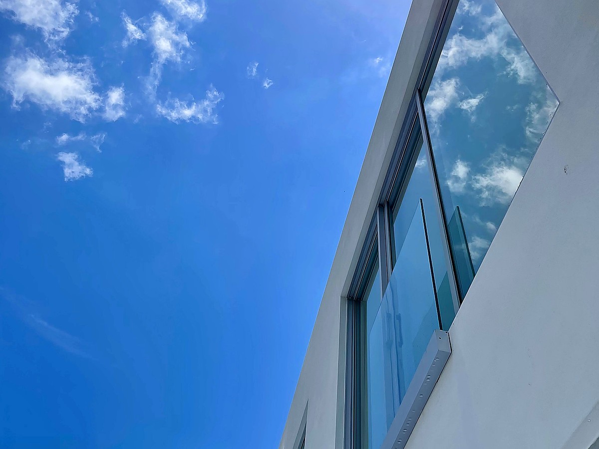 Modern Intracoastal estate with crystal clear floor-to-ceiling glass, pool, and tropical landscaping in Boca Raton FL