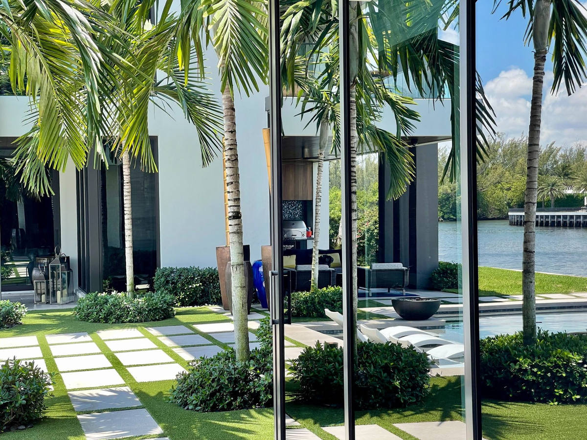 Elevated view of waterfront estate with pool deck and manicured landscape — Coastal Smart Property Care by Florida Boys Lawn & Landscape