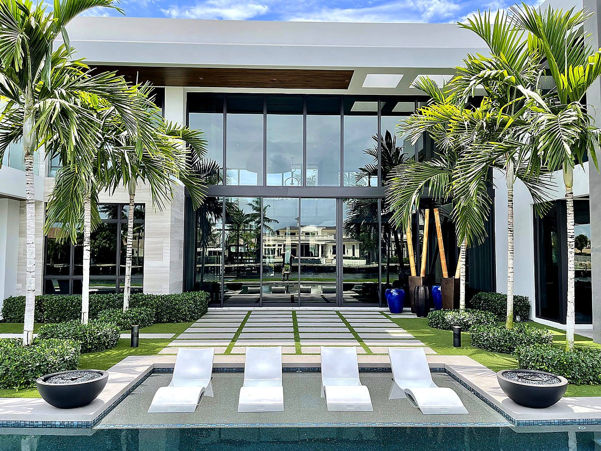 Intracoastal waterfront estate with hurricane impact glass, pool, and royal palms in Boca Raton