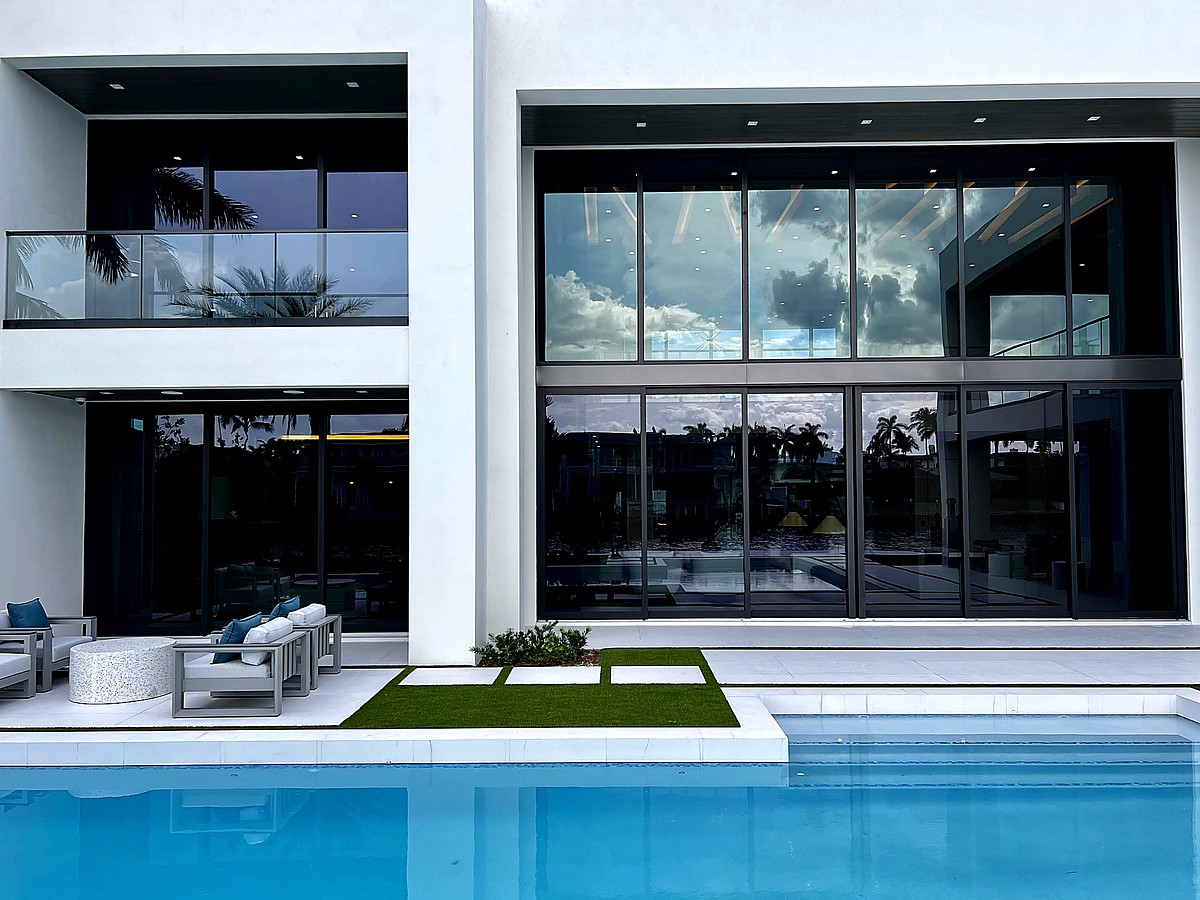 Luxury Gulf Stream estate with pristine floor-to-ceiling windows and pool