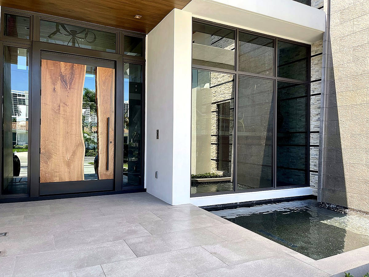 Modern estate entry with impact glass windows near fountain pool in Boca Raton