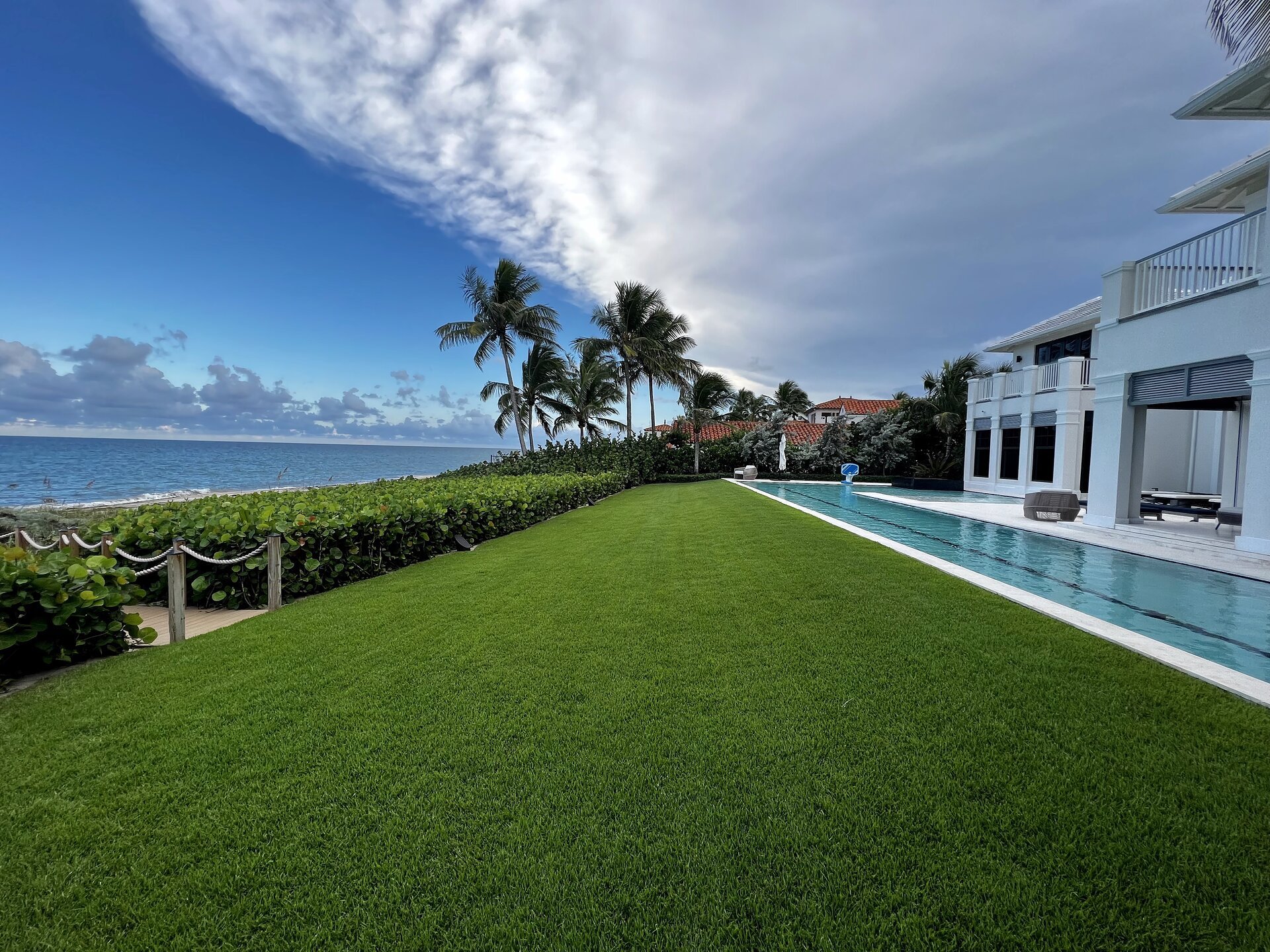 Manicured lawn and turf maintenance at South Florida estate with infinity pool