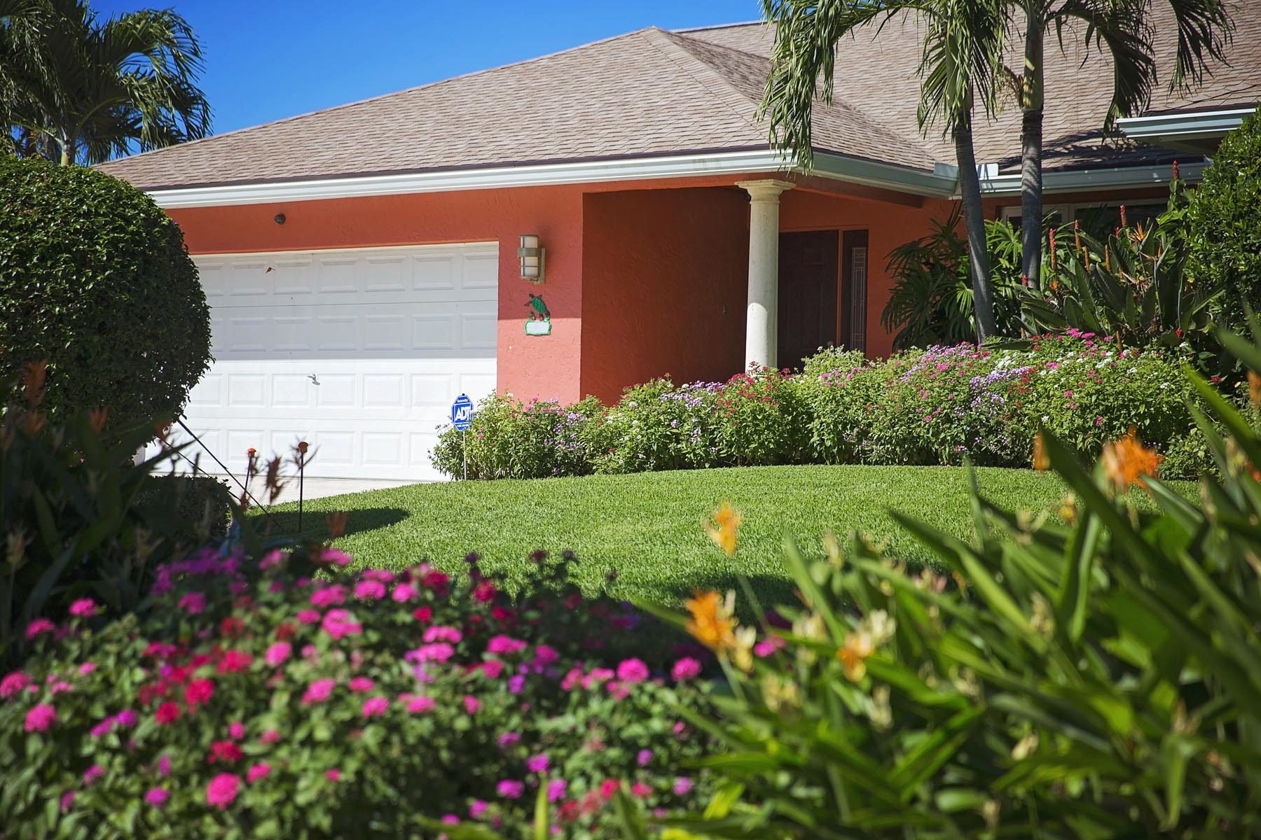 Residential lawn maintenance with colorful flower beds in Boca Raton