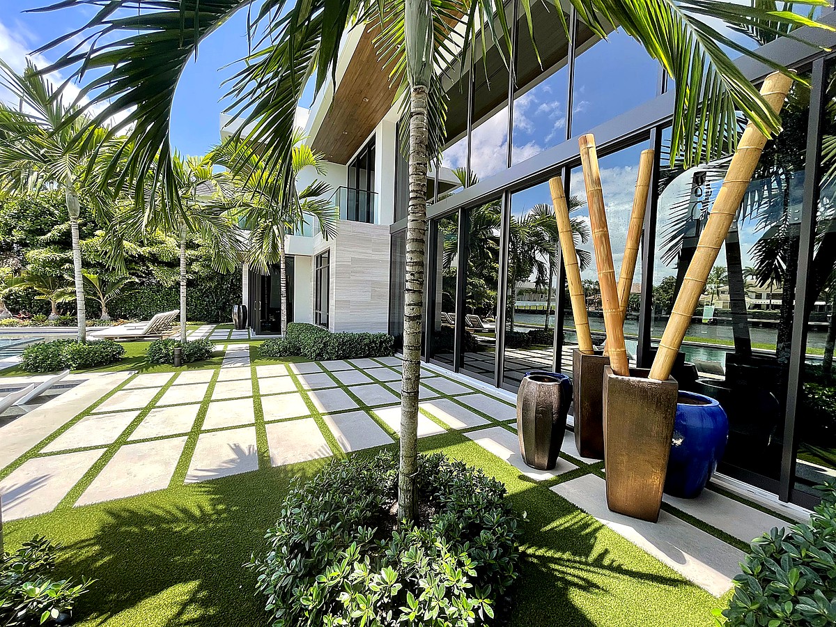 Modern home with tropical landscaping and pristine sliding glass doors in Boca Raton FL