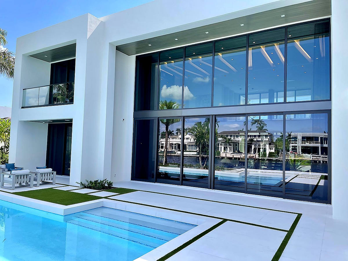 Modern Intracoastal estate with crystal clear floor-to-ceiling glass, pool, and tropical landscaping in Boca Raton FL