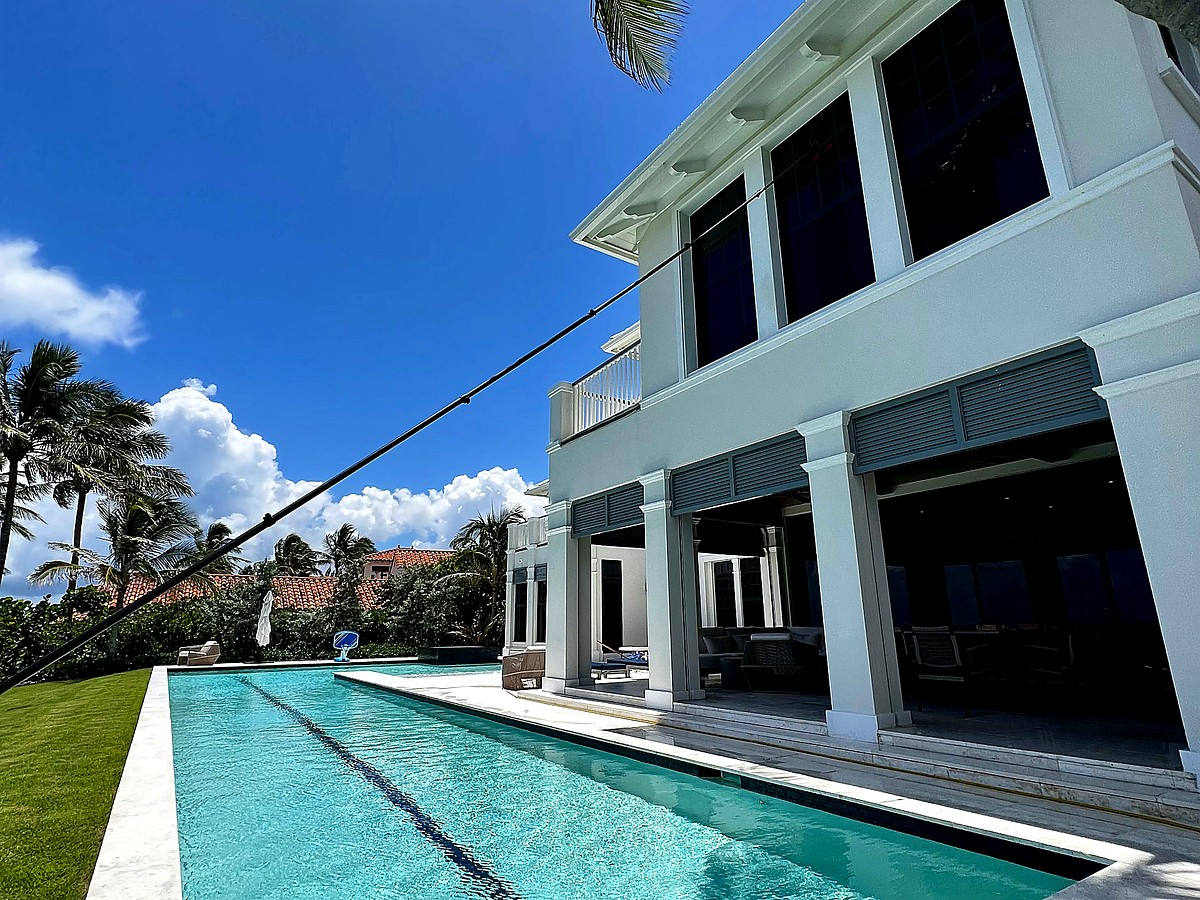 Professional water-fed pole window cleaning reaching second story at luxury Delray Beach estate